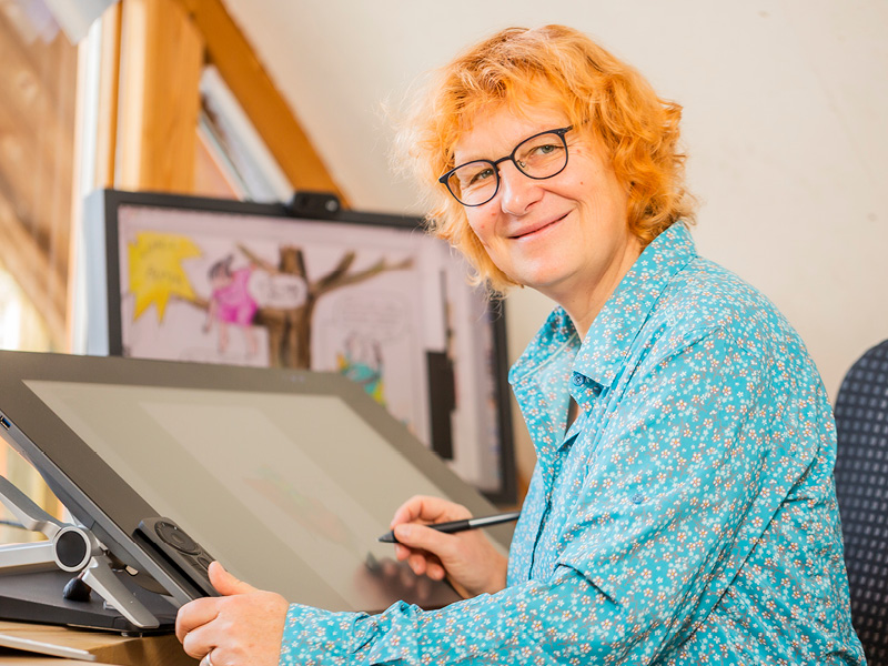 Felice Meer, Grafikdesignerin und Comiczeichnerin, sitzt am Grafiktablet in ihrem Atelier und zeichnet einen Comic